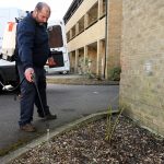 White male Mark Walker spraying weeds with van in background 2